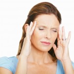 Closeup of a mature woman with a headache against white background
